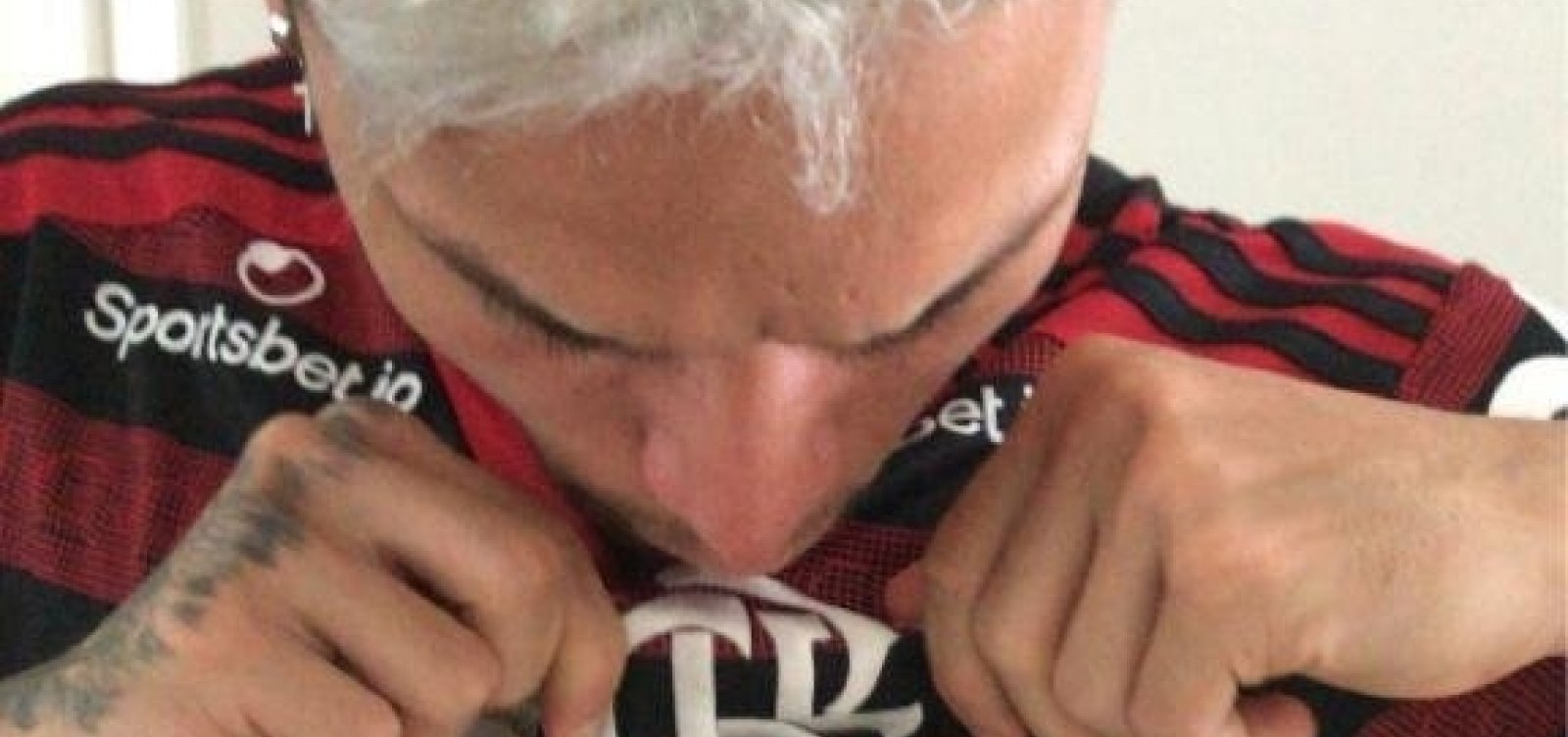 [Artur, do Bahia, aparece em foto beijando escudo do Flamengo]